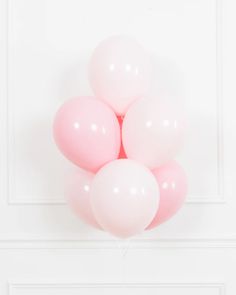 a bunch of pink balloons floating in the air