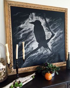 a black and white painting on a wall next to candles