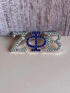 a blue and white brooch with the word zop on it's side