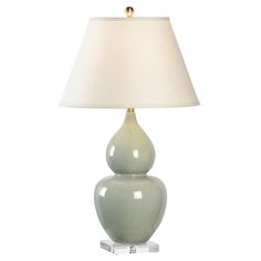 a green lamp with a white shade on it