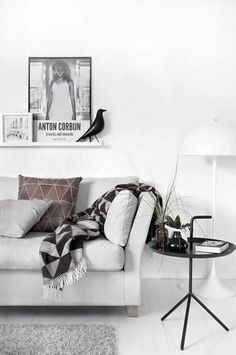 a living room with a couch, table and pictures hanging on the wall above it