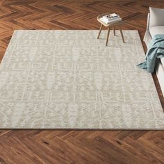 a living room with wooden floors and a white rug on top of a hard wood floor