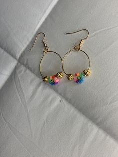 a pair of gold hoop earrings with colorful beads