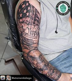 a man with a tattoo on his arm sitting in a chair