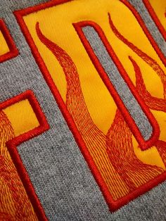 a close up of the letters and numbers on a t - shirt that is yellow and red