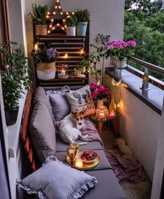 a small balcony with plants and candles on it