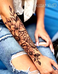 a woman's arm with flowers and leaves tattooed on the side of her leg