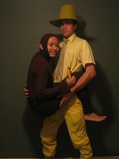 two people dressed in costumes and hats posing for a photo with one person holding the other