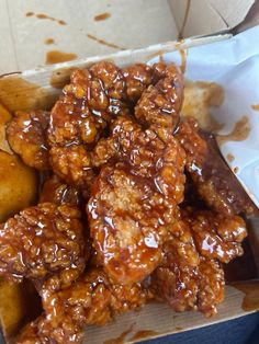 a box filled with lots of food sitting on top of a wooden table covered in sauce