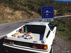 a white car is parked on the side of the road