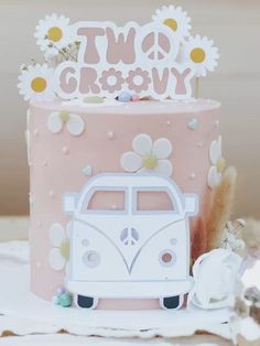 a pink and white cake sitting on top of a table