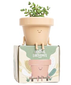 a plant in a pot sitting on top of a box that says original earthlings