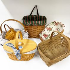 four wicker baskets sitting next to each other on a white counter top, one with a blue ribbon