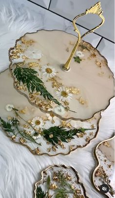 two plates with gold and white designs on them, one is holding a green plant