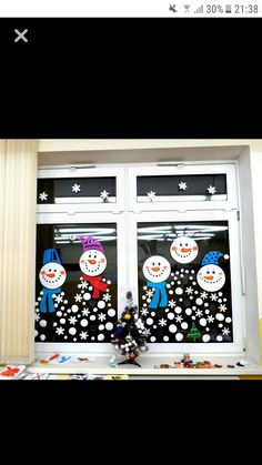 the window is decorated with snowmen and stars