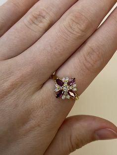 a woman's hand with a ring on it that has two stones in the middle