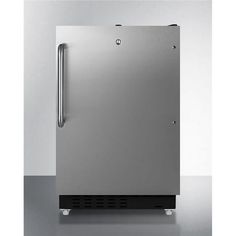 a stainless steel freezer sitting on top of a white counter next to a wall