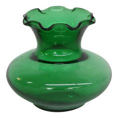 a green glass vase sitting on top of a white table