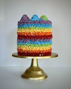 a multi colored cake sitting on top of a gold plate