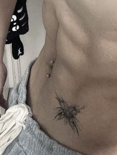 a shirtless man with a palm tree tattoo on his stomach