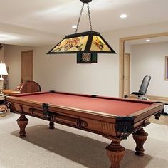 a pool table in the middle of a living room with two lamps on either side