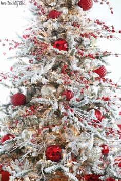 a white christmas tree with red and silver ornaments