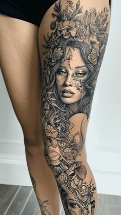 a woman's leg with tattoos and flowers on it