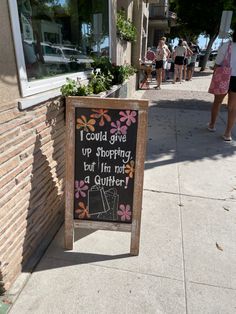 a sign on the sidewalk that says i could give up shopping but i'm not a quilter