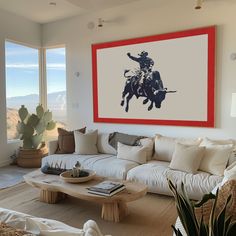 a living room filled with furniture and a painting hanging on the wall above it's windows