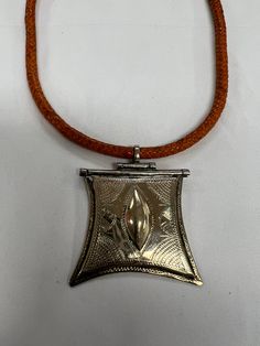 Vintage authentic Tuareg silver amulet necklace from Mali. Handmade of silver with detailed engraving with handmade Red or Black leather strap. The necklace is an approximately 17-inch necklace. It is Stunningly beautiful and very lightweight. Due to ongoing fighting in Mali, Tuareg jewelry is increasingly harder to find today. This is a lovely statement piece. Please expect minor imperfections due to the hand-crafted nature and age of the item. SIZE: The amulet measures approximately 2 1/4". x Traditional Silver Necklace With Square Pendant, Traditional Engraved Necklaces For Festivals, Traditional Engraved Necklace For Festival, Traditional Adjustable Locket Necklace, Traditional Etched Antique Silver Necklace, Traditional Adjustable Engraved Necklaces, Traditional Silver Etched Necklace, Traditional Etched Necklace For Festival, Adjustable Engraved Necklaces For Rituals