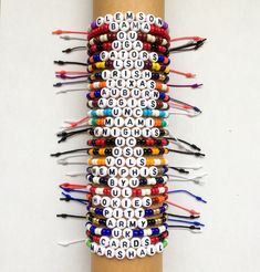 several bracelets are arranged on top of each other with words written in letters and numbers