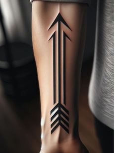 a person's leg with an arrow tattoo on the lower part of their leg