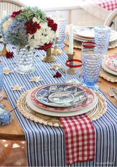 the table is set with plates and place settings