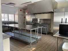 an industrial kitchen with stainless steel appliances and tile flooring is pictured in this image