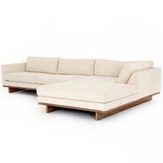 a white sectional couch sitting on top of a wooden frame