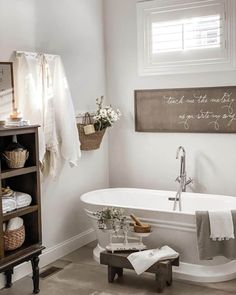 a white bath tub sitting next to a wooden shelf