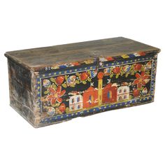 an old wooden chest with painted designs on the front and sides, isolated against a white background