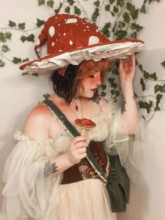 a woman wearing a red and white hat holding an ice cream cone in front of her face