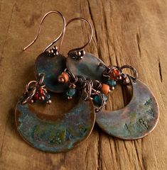 Primitive copper stamped two part connected earring design with crescent shaped lower and oval shaped upper components. The solid copper components are treated with a green patina and a coat of jewelry grade lacquer to protect the color. Dangles in sun drenched orange and watery blue add a touch of color. The solid copper earwires are a four ball cluster design, making the total length of the earrings 2.5 inches, and still a comfortable weight for their size. Your package will come to you gift w Bohemian Stamped Copper Jewelry, Green Copper Earrings With Patina, Primitive Jewelry, Rustic Orange, Metal Stamped Jewelry, Paper Bead Jewelry, Cluster Design, Copper Jewelry Handmade, Green Patina