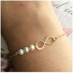 "★ ITEM DESCRIPTION: * Yellow gold filled infinity charm (20 mm x 8 mm, a little smaller than 1 inch) * Swarovski pearls 5 mm (0.19 in.) * Single yellow gold filled chain * Yellow gold filled lobster clasp * Gift box ✤ Sterling silver: https://www.etsy.com/listing/218099238 ✤ Rose gold: https://www.etsy.com/listing/542418988 ★ HOW TO ORDER: 1/ Select your bracelet length - see sizing chart in listing pictures. XS - 6\" S - 6.5\" M - 7\" L - 7.5\" XL - 8\" 2/ Select your pearl color. Why not choo Hypoallergenic Rose Gold Infinity Jewelry, Infinity Metal Jewelry For Wedding, Adjustable White Infinity Jewelry, Elegant Hypoallergenic Infinity Jewelry, Gold Infinity Shaped Metal Jewelry, Simple Metal Jewelry As A Gift, Minimalist Nickel-free Infinity Jewelry, Simple Metal Jewelry As Gift, Hypoallergenic Infinity Jewelry For Everyday