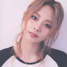 a woman with long hair wearing a black and white shirt is posing for the camera