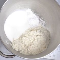 a metal bowl filled with flour on top of a table