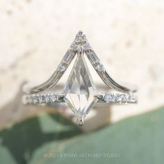 a diamond ring sitting on top of a green leaf