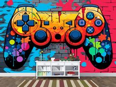 a video game controller painted on the side of a brick wall with colorful paint splatters