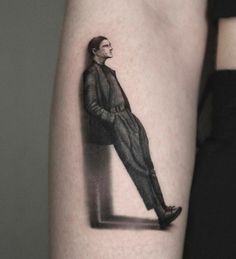 a woman's arm with a black and white photo of a man in a suit