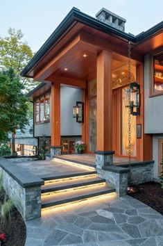 a modern house with stone steps leading up to the front door and entryway area