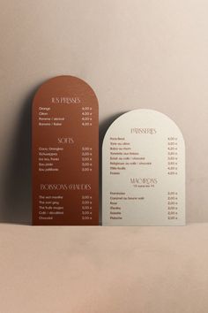 two menus sitting on top of a table next to each other in front of a wall