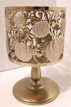 an ornate gold candle holder on a white table