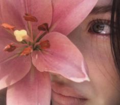 a close up of a person's face with a flower in front of her