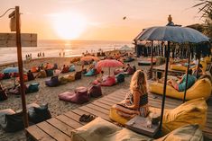 a group of people sitting on bean bags at the beach